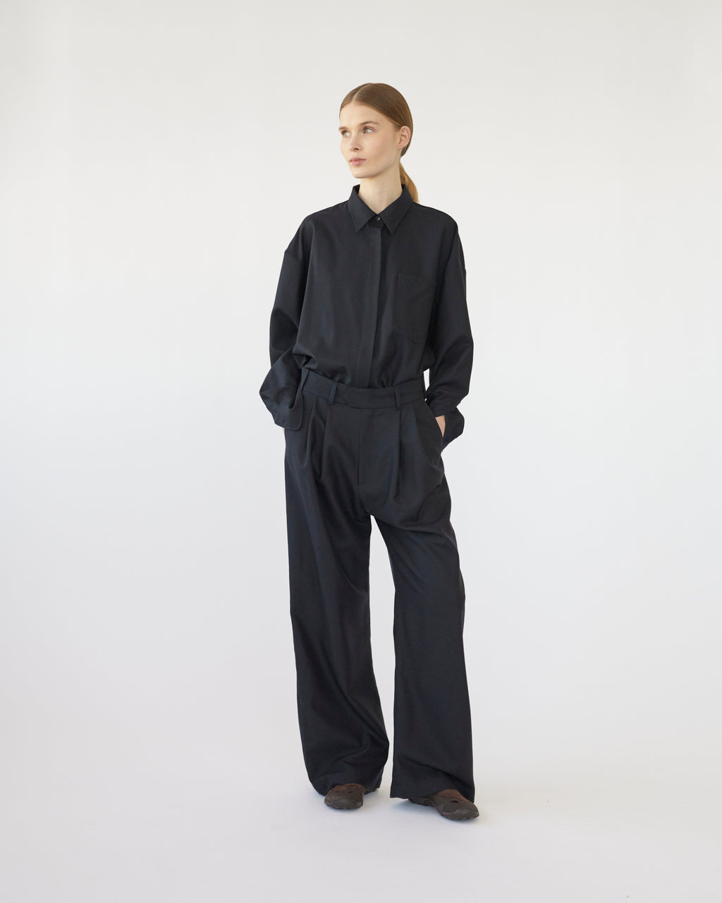 Model wearing a navy outfit on a white background.