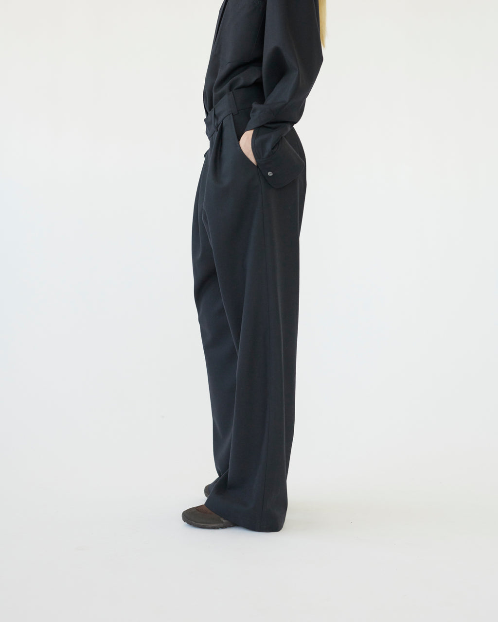 Model wearing navy pants on a white background