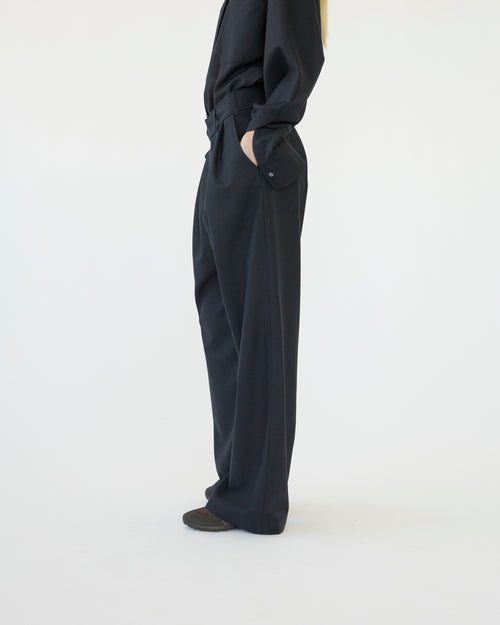 Model wearing navy pants on a white background