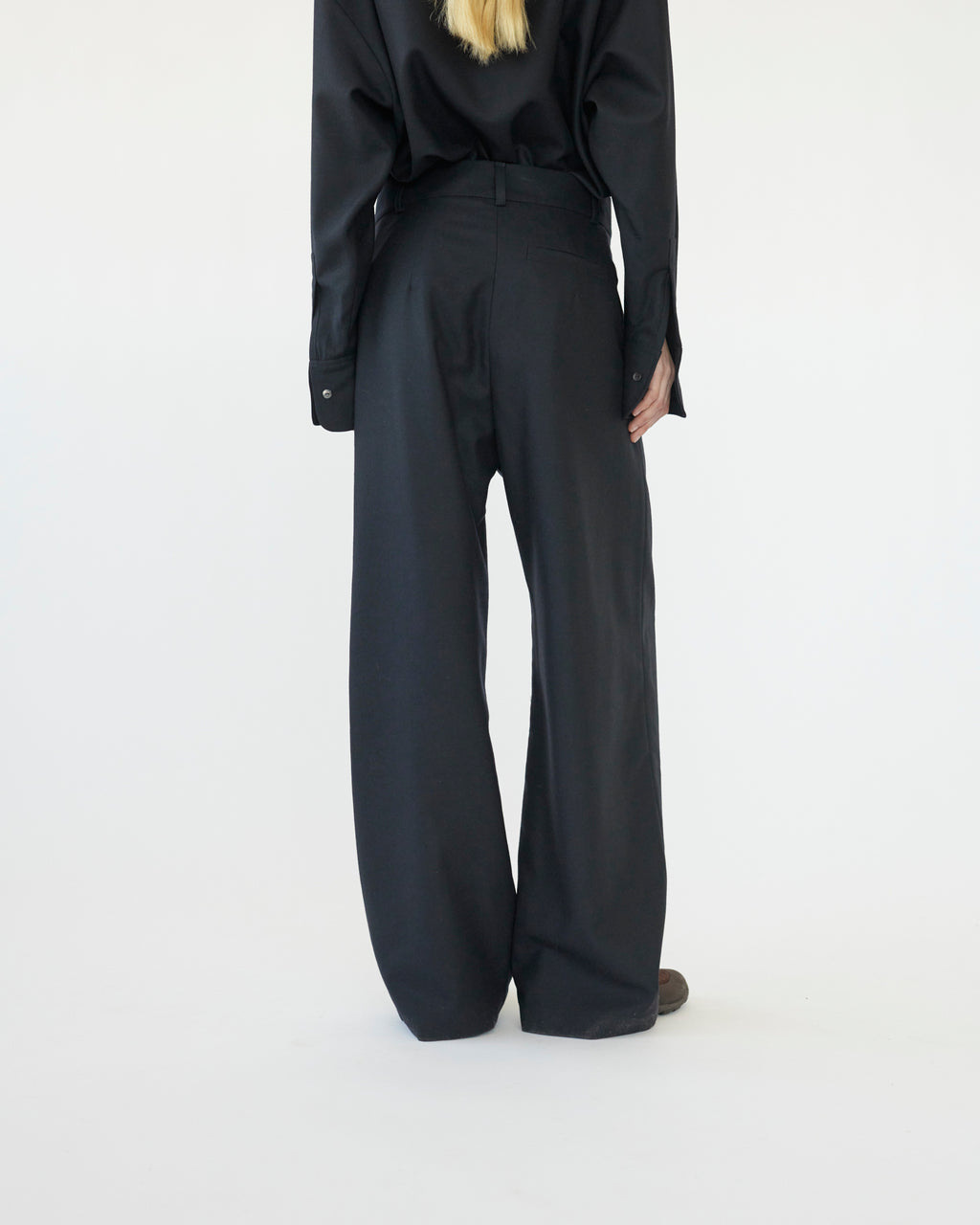 Model wearing a navy outfit with wide-leg pants on a white background