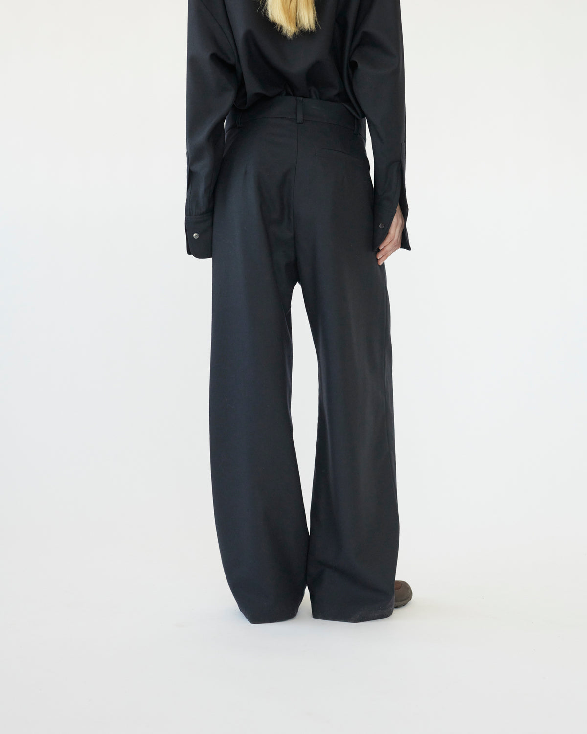 Model wearing a navy outfit with wide-leg pants on a white background