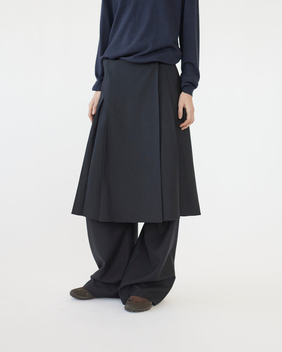  Model wearing a dark blue top and navy skirt on a white background