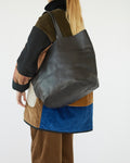 Person wearing a black totebag with a neutral background