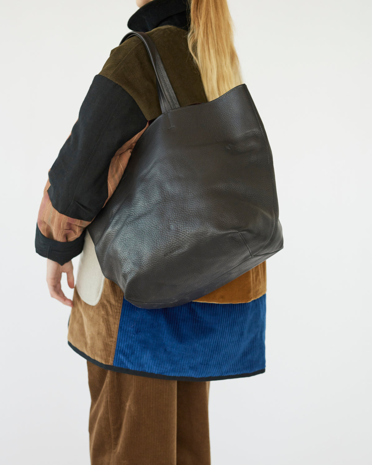 Person wearing a black totebag with a neutral background