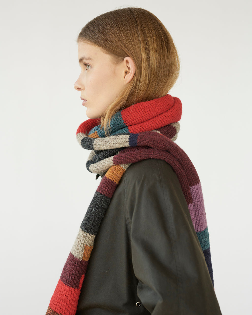 Person wearing a colorful striped scarf on a white background