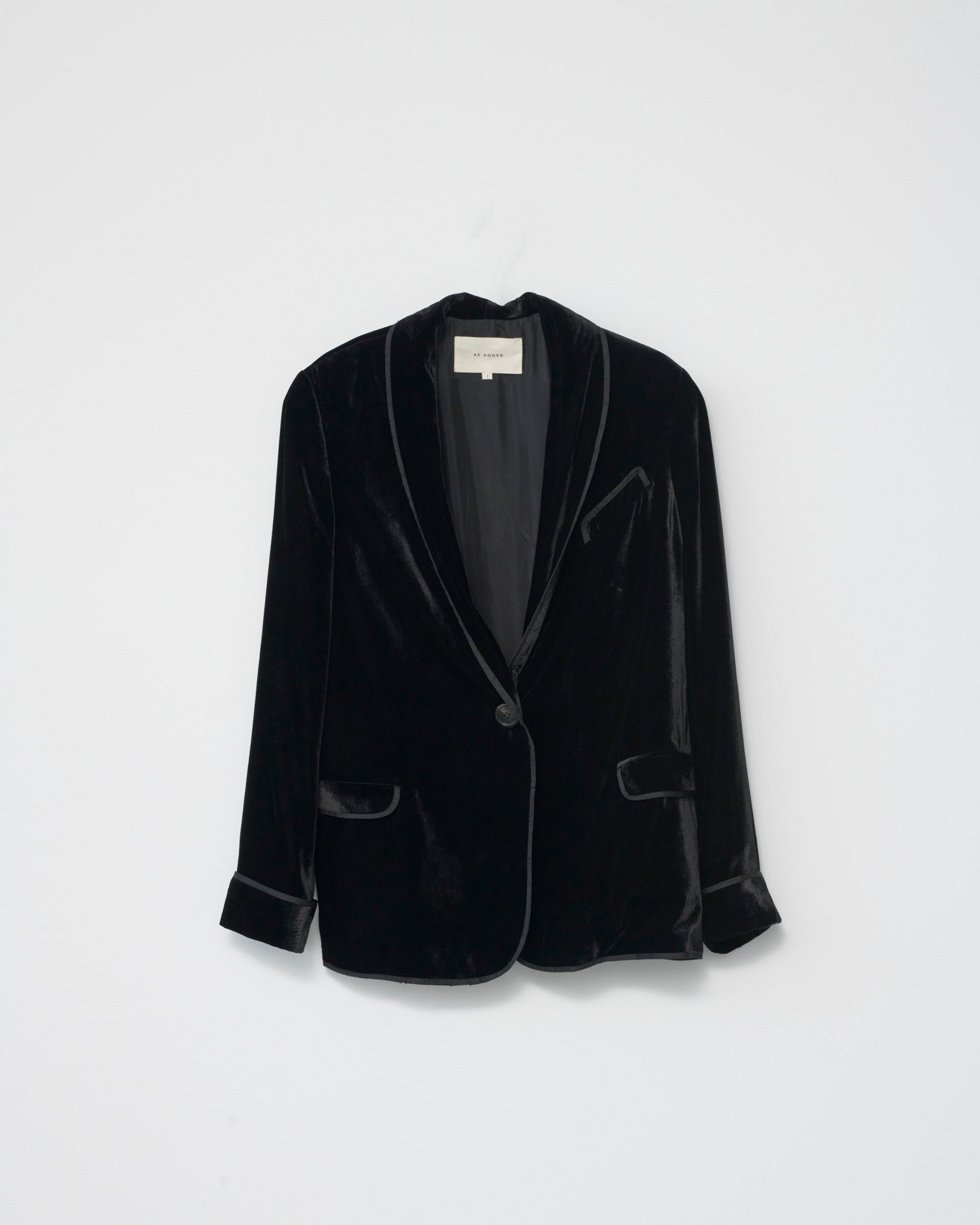Black silk velvet blazer on a light gray background. Front view