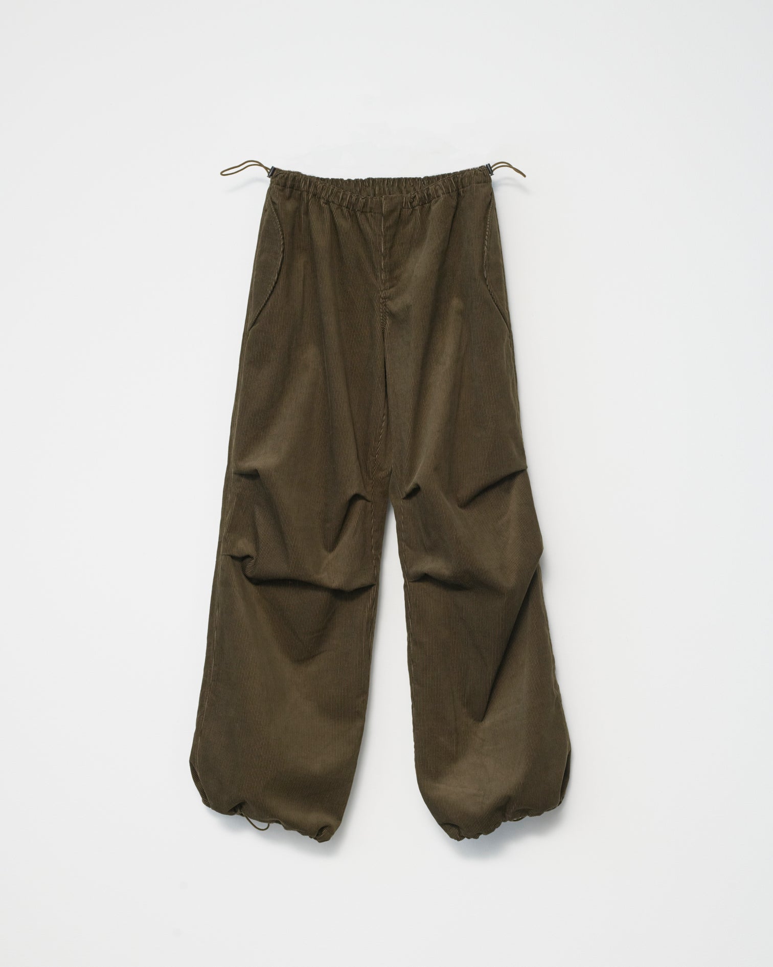 a pair of wide-leg corduroy trousers in tobacco with an adjustable elastic waistband. White background, front view.