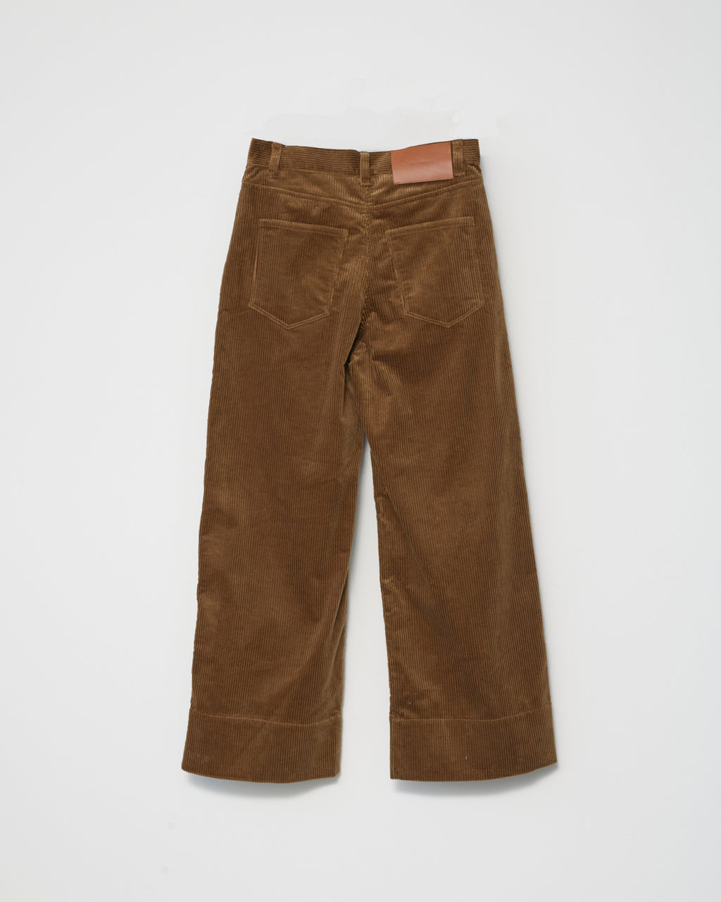 A pair of cognac-colored corduroy trousers against a white background back  view.