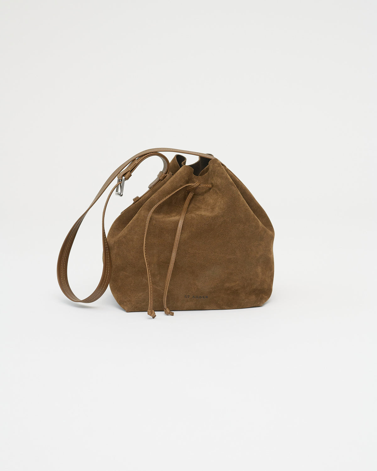 Brown suede handbag with a strap on a white background. Front view