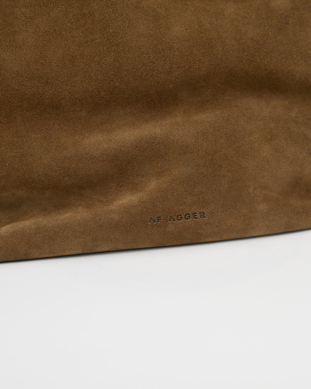 Brown leather bag with 'AF AGGER' branding on a white background