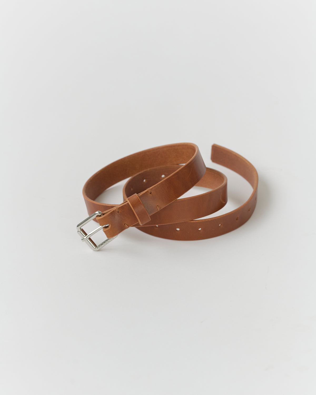 A narrow brown leather belt with a metal buckle, displayed on a white background.